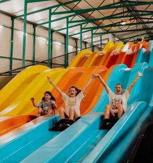 a group of people riding down a slide on a water slide