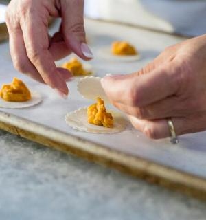 osoba držící špachtli nad jídlem na tácu