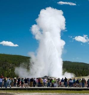 a crowd of people standing in front of a geyser