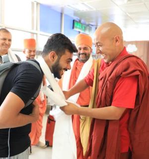 a group of men in orange turbans in an airport