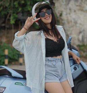 žena stojí vedle motorky