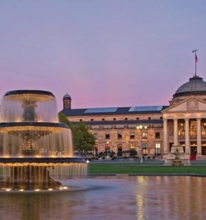 ein großes Gebäude mit einem Brunnen vor einem Gebäude