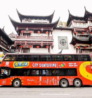 a red double decker bus parked in front of a building