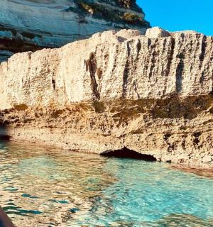 a boat in the water next to a cliff