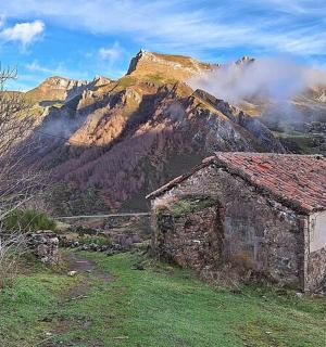 an old building on a hill with a mountain