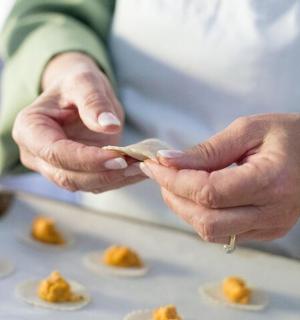 osoba držící v rukou kus jídla