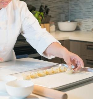 一位女士在厨房里用砧板准备食物