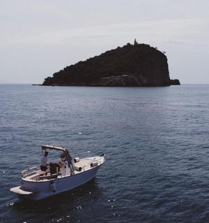 a boat in the water with an island in the distance
