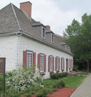 一座有红色窗户和标志的古老白色建筑