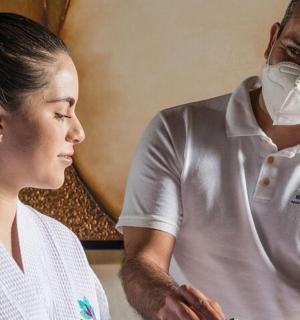 一名戴着口罩的男子站在一名女子旁边