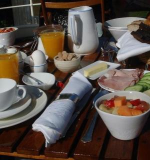 a wooden table with breakfast foods and drinks on it