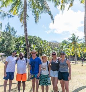 a group of people standing in front of palm trees