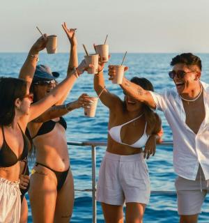 一群人站在船上,手里拿着饮料