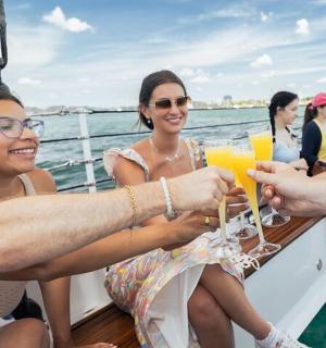 skupina lidí pijících víno na lodi