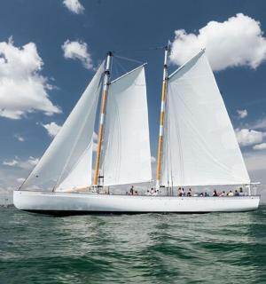 a boat with white sails in the water
