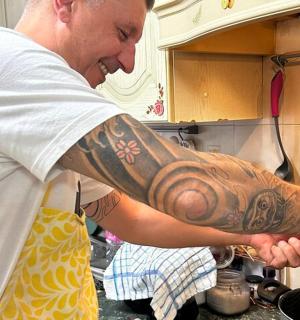 厨房里，一名手臂上有纹身的男子