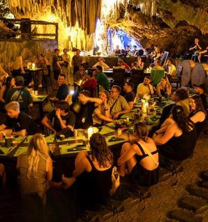 一群人坐在洞穴里的桌子旁