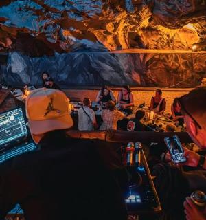 a group of people sitting in front of a large painting