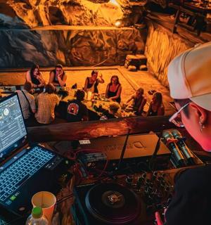 a woman sitting in front of a laptop computer in a cave