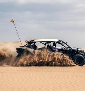an atv driving in the sand in the desert
