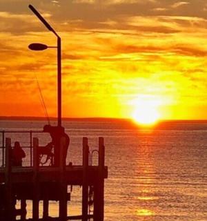 molo s lidmi na něm a západ slunce