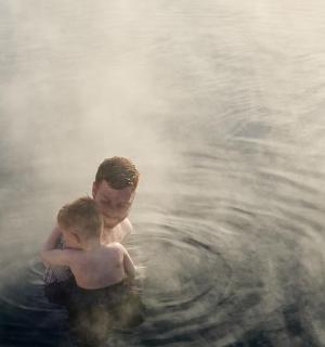 a man and a child in the water in a steam bath