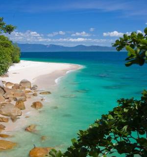a beach with a bunch of rocks in the water