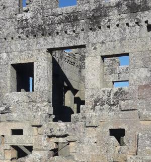 an old stone building with windows on top of it