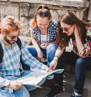 三个人坐在台阶上看地图