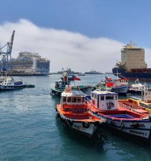 Skupina lodí zakotvených v přístavu s výletní lodí