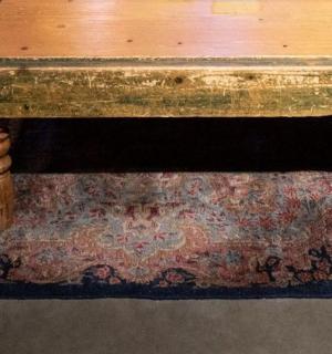 一个人站在地毯上的木桌旁