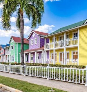 a row of colorful houses with a white fence