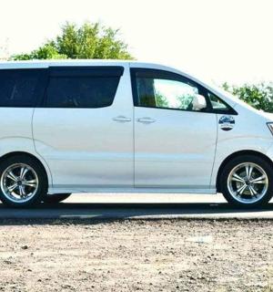 bílá dodávka zaparkovaná na štěrkovém parkovišti