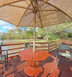 甲板上有一张桌子和几把椅子，还有一把遮阳伞