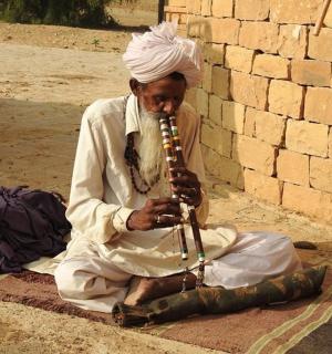 一名男子坐在地上演奏乐器