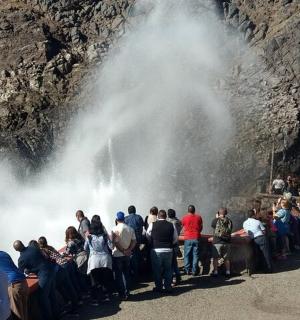 a crowd of people standing in front of a waterfall