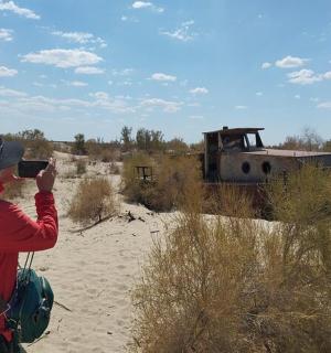 一个人在沙漠中拍摄一座老建筑