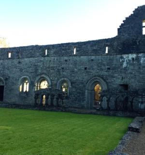 stará kamenná budova se zeleným trávníkem před ní