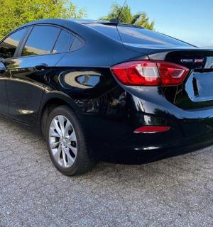 一辆黑色汽车停在水边的路上