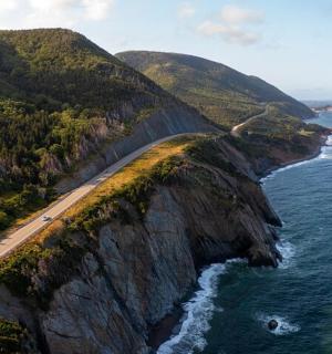 a road on top of a cliff next to the ocean