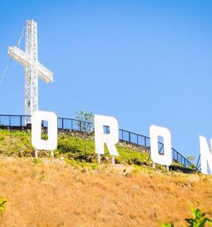 ein Kreuz auf der Spitze eines Hügels mit Stühlen