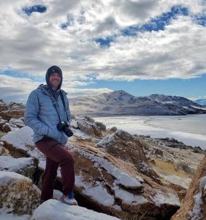 一位妇女坐在白雪皑皑的山顶上