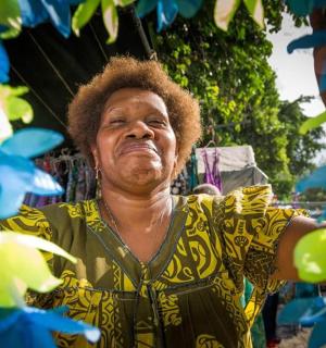 a man standing next to some green and blue flowers