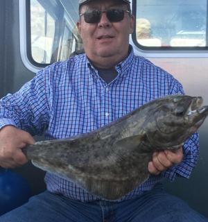 muž držící v rukou velkou rybu