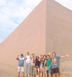 a group of people standing in front of a pyramid