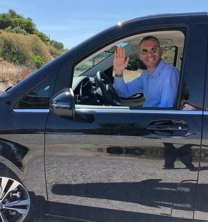 ein Mann sitzt auf dem Fahrersitz eines Autos