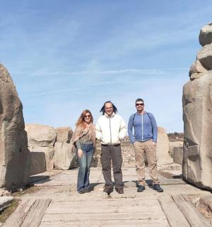 three people standing in front of a statue