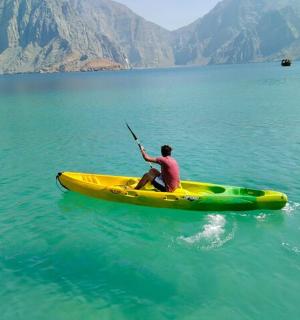 一名男子在水中划着黄色皮艇