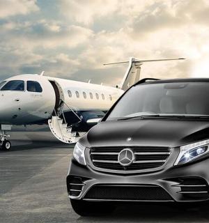 一辆豪华轿车停在一架飞机旁边