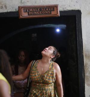 一名女子站在门口,手里拿着一块牌子